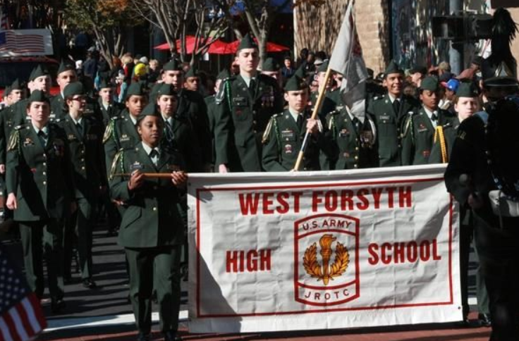 JROTC proudly marches with their West banner. Each year the marching band and JROTC get the chance to be in the Veterans Day Parade.