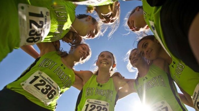 The girls cross country team huddles before the state championship meet. West took second place at the meet November 3.