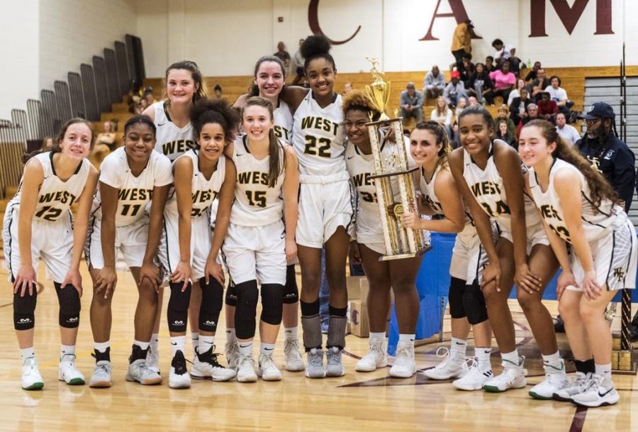 Girls basketball flashes their first-place trophy following the Mary Garber Tournament. 