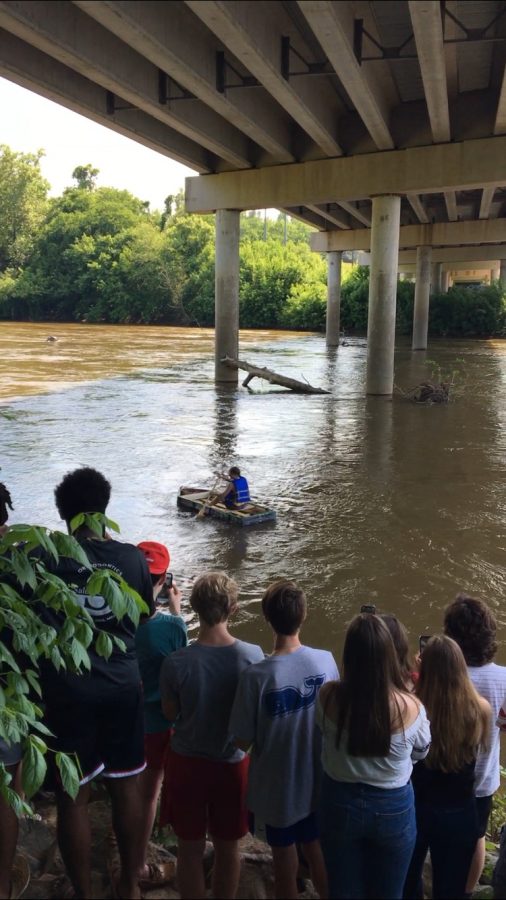 Senior Cameron Gravely sails down the Yadkin River in a homemade rowboat. A crowd of students and friends cheered him on with Beethovens 5th as he rowed away.