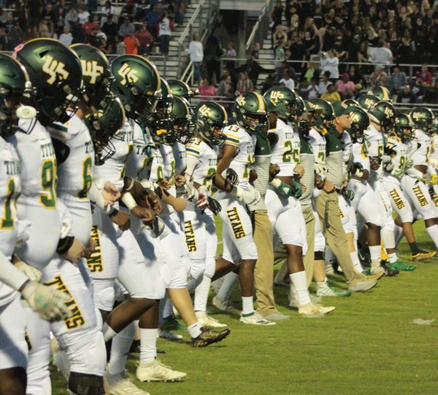 Varsity football players stand united as they prepare to take on the East Forsyth Eagles last fall. The Titans hope to play a condensed season in February.