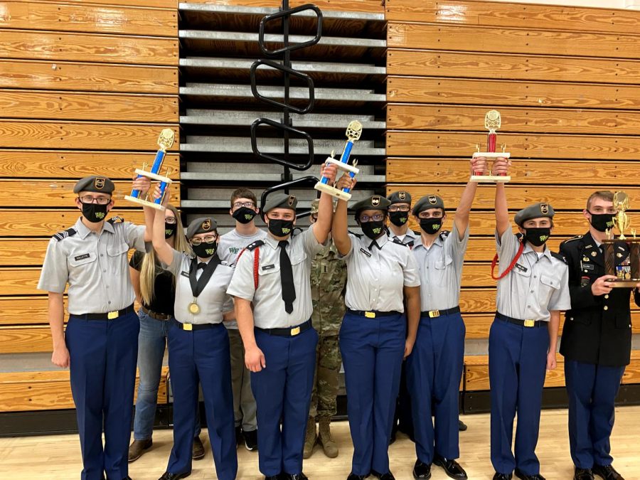 The+JROTC+students+raise+their+trophies+high+after+placing+in+competition.+The+program+is+a+tight+knit+community%2C+always+working+together+to+do+their+best.+