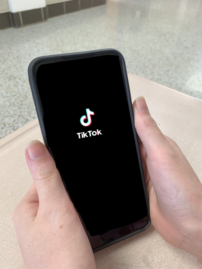A+person+using+TikTok+on+their+phone.