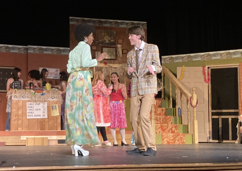 Wally, played by Evan Wilmoth, and Ellen, played by Morgan Spaulding participate in a hula dancing scene on stage