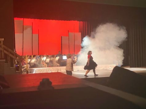 Nick Peterson-Paugh (left) and Laurel Chiesa (right) dance on stage in musical rehearsal.