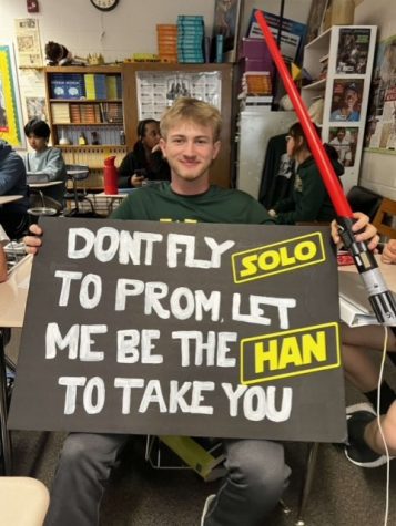 Ethan Schiedel shows off his prom-posal poster.