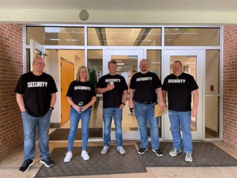 Science staff stands together with their security shirts on.
