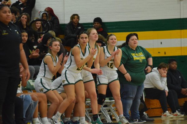 Girls basketball players cheering their teammates on from bench during regular season home game against East Forsyth.