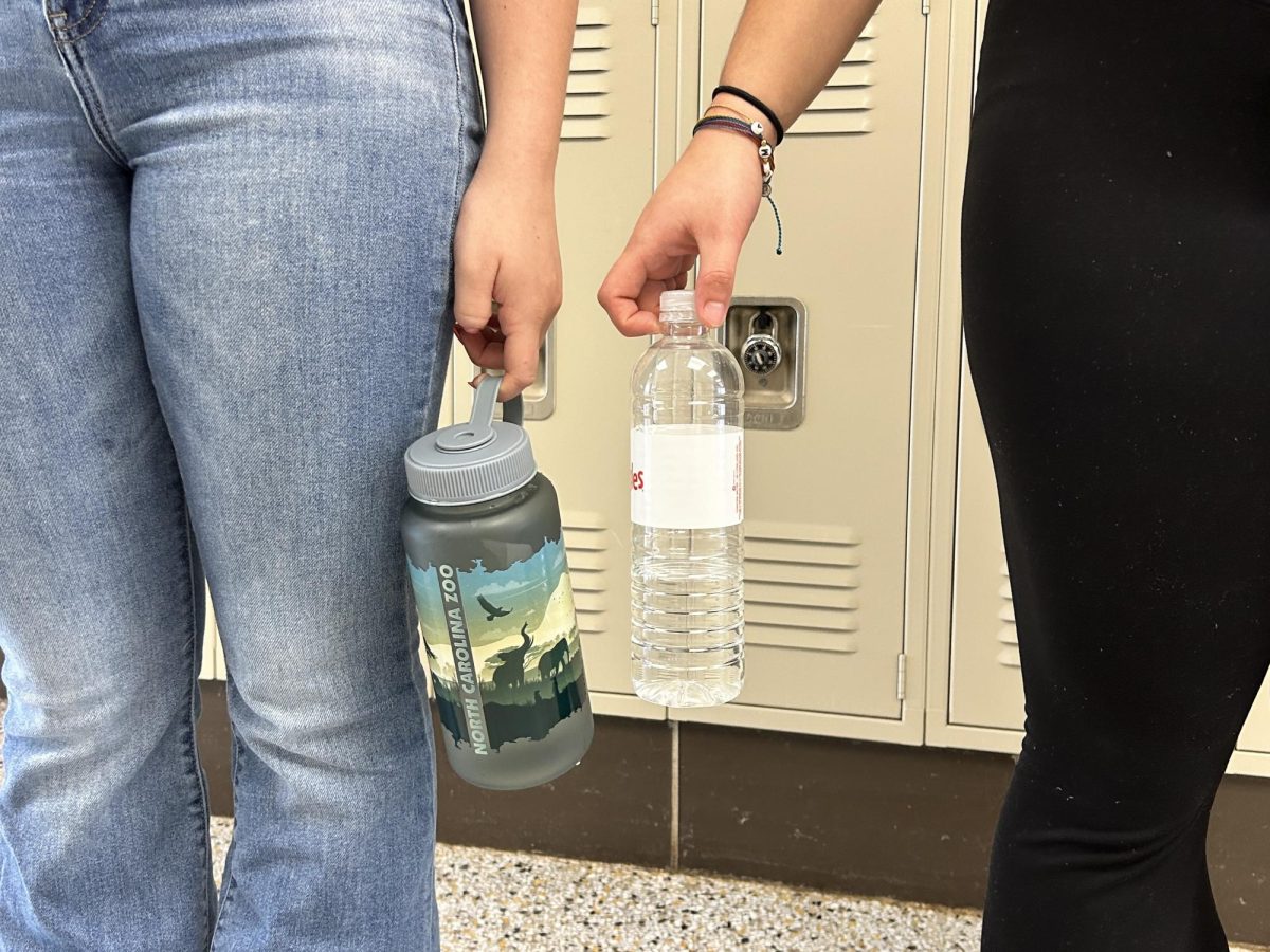 West+students+displaying+their+reusable+and+single+use+water+bottles.+