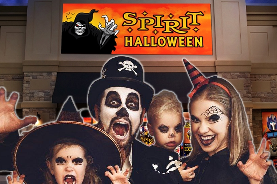 A family poses in front of Spirit Halloween